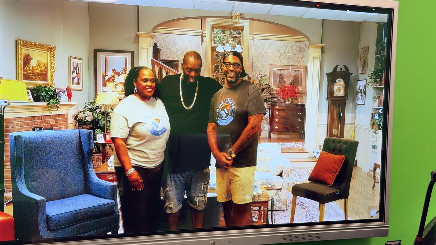 Three attendees pictured on a monitor at the MBV booth